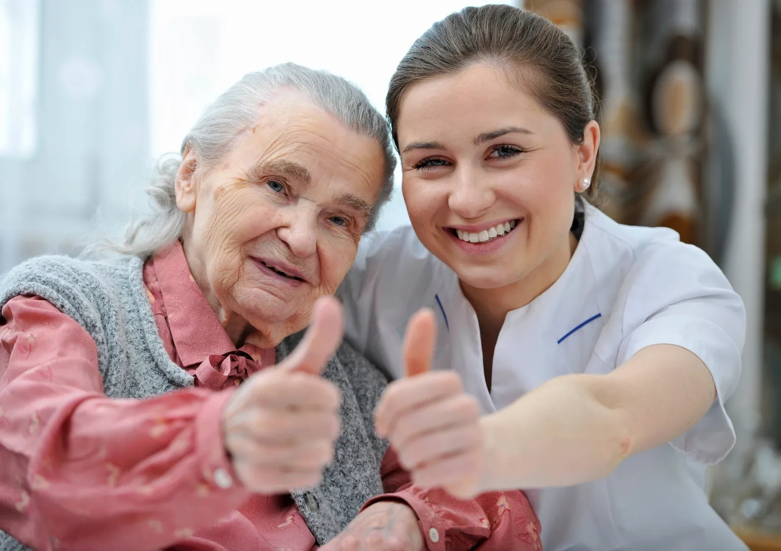 A woman and an old lady giving thumbs up.